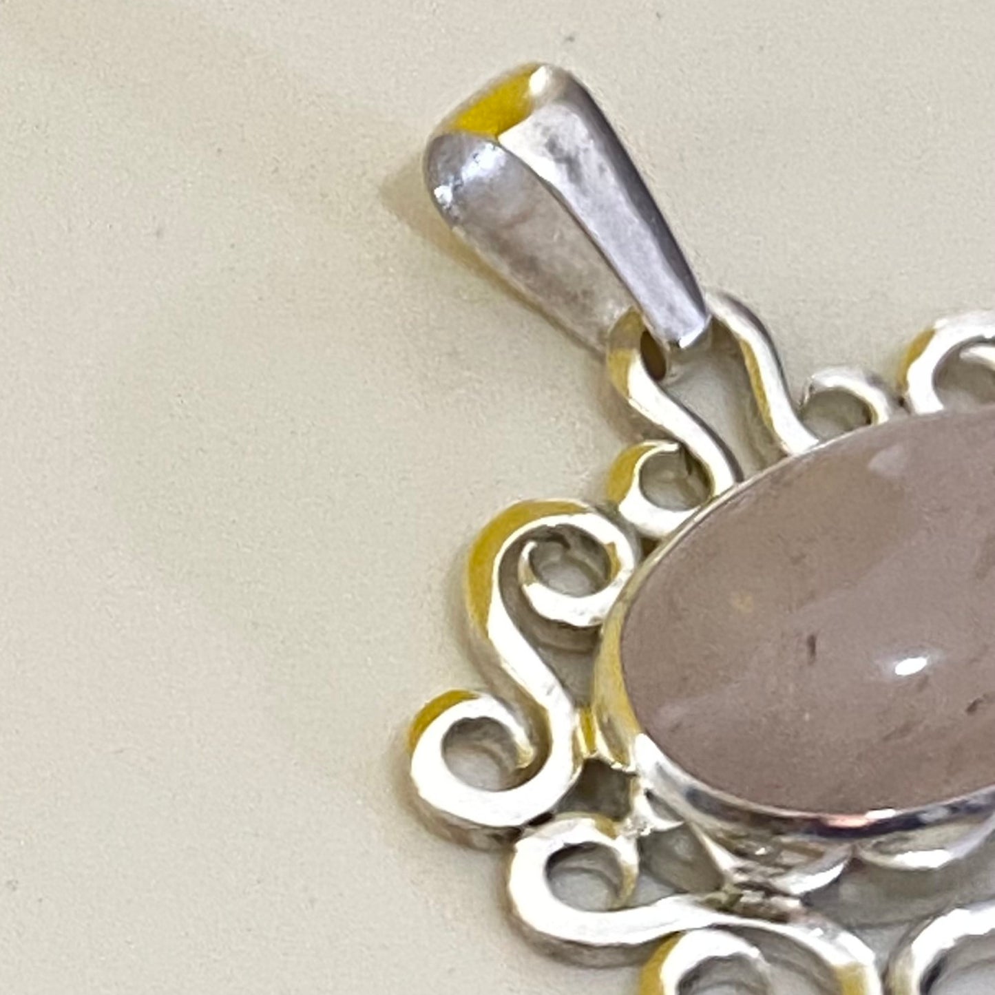 Artisanal Jewelry (Joyería Artesanal) en Plata 950. Primer plano detallado del soporte y la gema Cuarzo Rosa, sobre fondo claro, mostrando el acabado de la plata (Medellín).