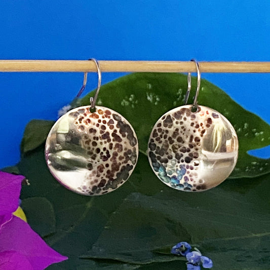 Par de Aretes de Plata Fina 950 de Joyería Fina, con diseño circular martillado y pavonado. Colgando de un palito de bambú, decorados con hojas silvestres y buganvilla discreta (Bucaramanga).